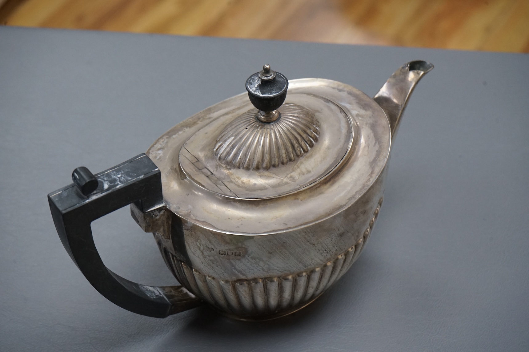 An Edwardian demi-fluted silver oval teapot, by Goldsmiths & Silversmiths Co Ltd, London, 1901, gross 18.8oz.
